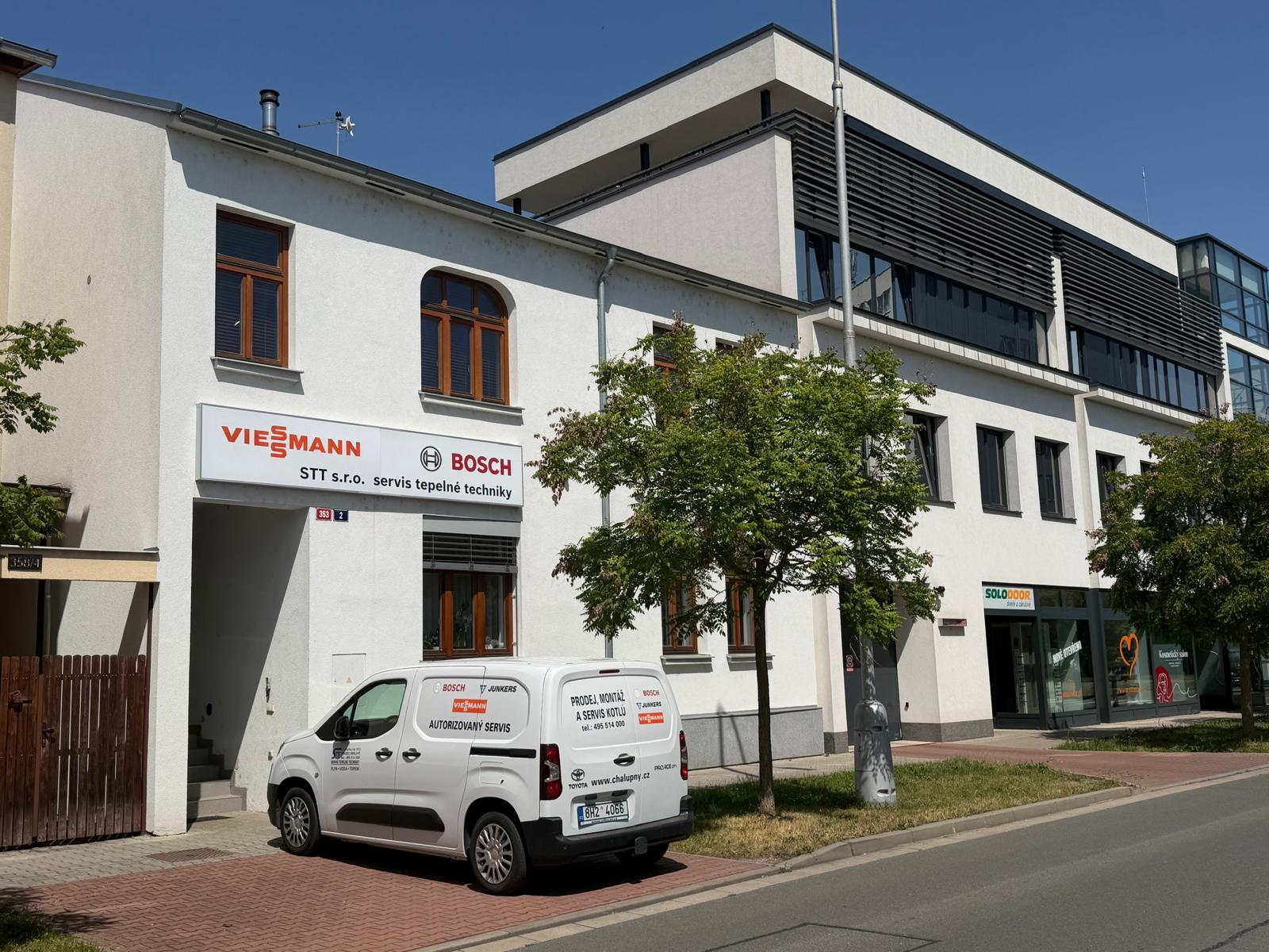Provozovna STT s.r.o. na Jiřího Purkyně 353 v Hradci Králové – bílá budova s cedulí Viessmann a Bosch a servisním vozem před vchodem